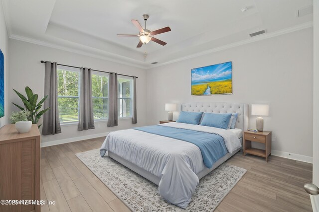 121 Oxford Estates Way, Saint Johns, FL 32259 - bedroom with crown molding, visible vents, light wood-style floors, a tray ceiling, and baseboards