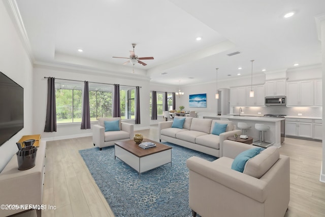121 Oxford Estates Way, Saint Johns, FL 32259 - living room featuring a tray ceiling, visible vents, light wood-style flooring, and ceiling fan with notable chandelier