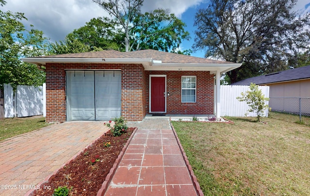 8413 Free Ave, Jacksonville, FL 32211 - view of front of home featuring brick siding, a front lawn, fence, and a garage