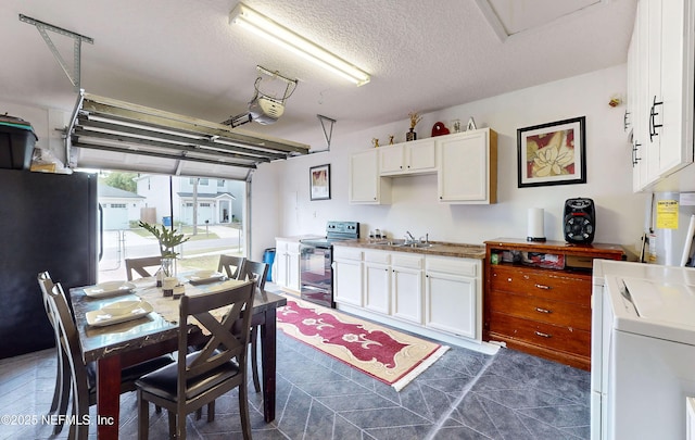8413 Free Ave, Jacksonville, FL 32211 - kitchen with a textured ceiling, separate washer and dryer, white cabinets, a sink, and black range with electric cooktop