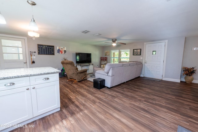 living area featuring baseboards, dark wood-style flooring, visible vents, and a ceiling fan