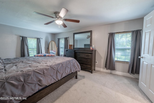 bedroom featuring ceiling fan, light colored carpet, and baseboards