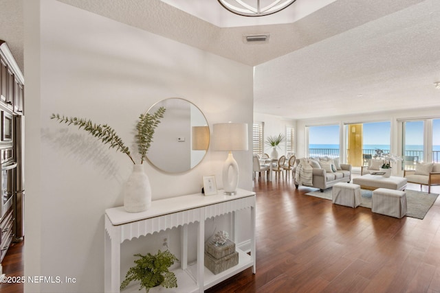 210 N Serenata Dr Unit 521, Ponte Vedra Beach, FL 32082 - interior space featuring a water view, a textured ceiling, visible vents, and dark wood-type flooring