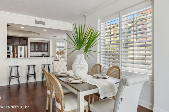 210 N Serenata Dr Unit 521, Ponte Vedra Beach, FL 32082 - dining area featuring visible vents, ornamental molding, dark wood-style flooring, baseboards, and a textured ceiling