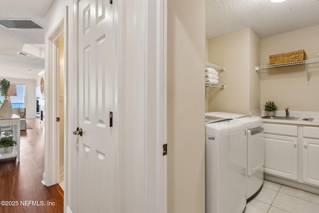 210 N Serenata Dr Unit 521, Ponte Vedra Beach, FL 32082 - washroom with cabinet space, separate washer and dryer, a textured ceiling, and a sink