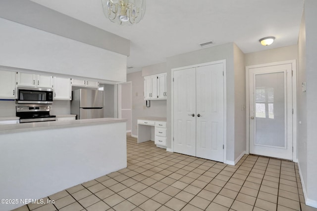 kitchen featuring white cabinets, stainless steel appliances, light countertops, and visible vents