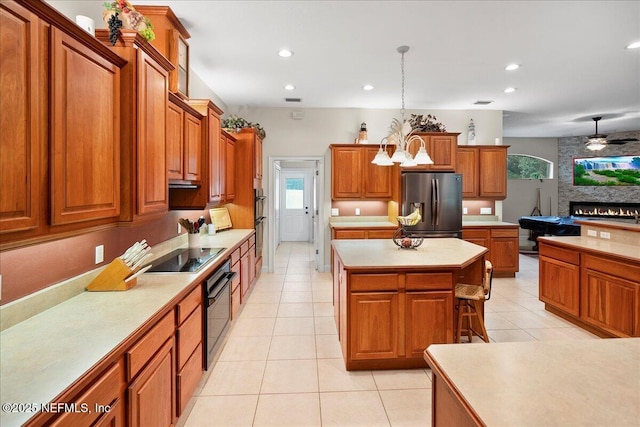 15 Dartmouth Trce, Ormond Beach, FL 32174 - kitchen with black electric cooktop, stainless steel refrigerator with ice dispenser, brown cabinetry, and light countertops