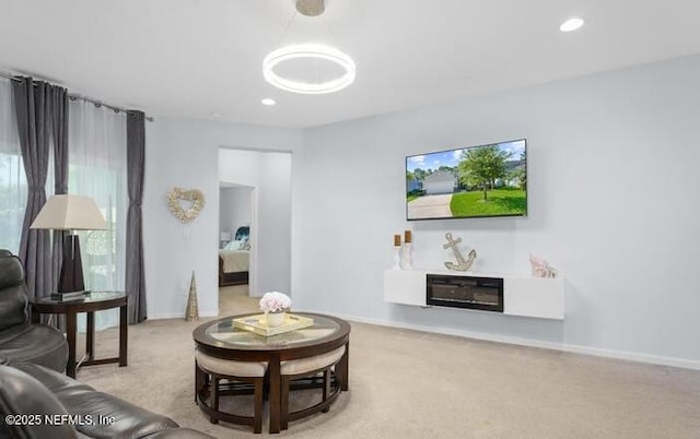 living room with carpet floors, baseboards, recessed lighting, and a glass covered fireplace
