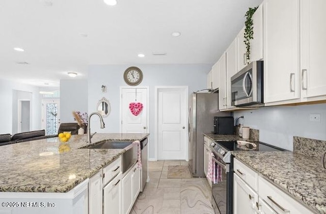 kitchen with white cabinets, recessed lighting, a sink, stainless steel appliances, and a center island with sink