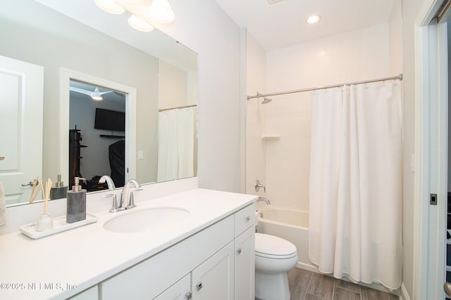 bathroom with shower / bath combo, wood finished floors, vanity, toilet, and recessed lighting