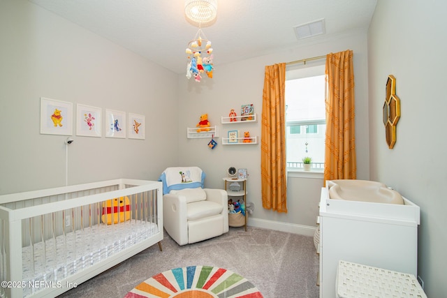 carpeted bedroom with visible vents, a crib, and baseboards
