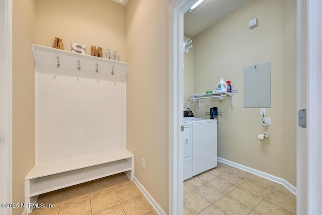mudroom with washing machine and dryer, baseboards, and light tile patterned flooring