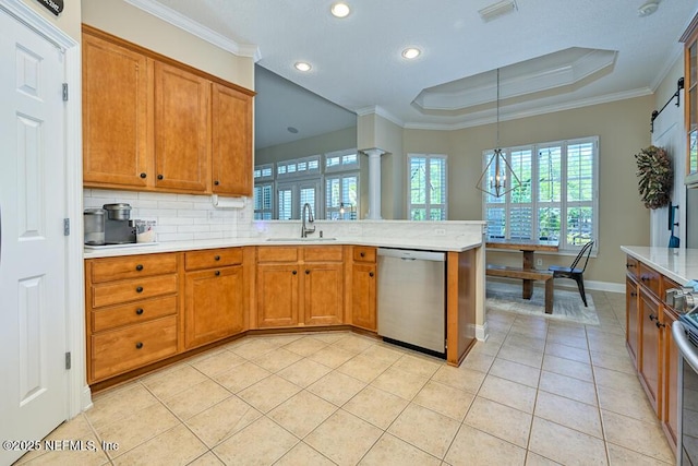 kitchen with a peninsula, stainless steel dishwasher, a sink, visible vents, and brown cabinetry