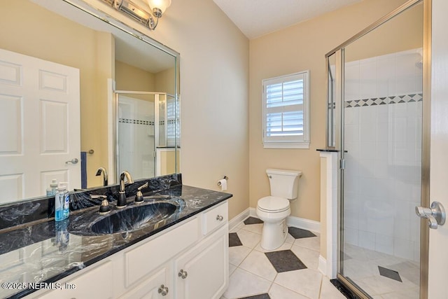 full bath featuring tile patterned floors, toilet, baseboards, a shower stall, and vanity