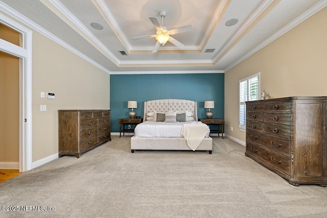 bedroom with visible vents, light carpet, a tray ceiling, and crown molding