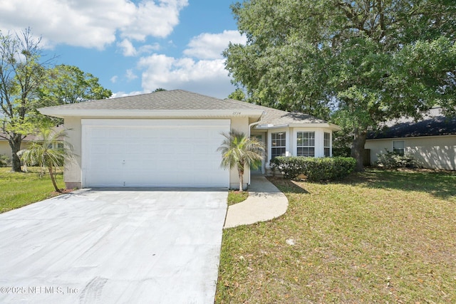 2734 Indigo Hills Ct, Jacksonville, FL 32221 - ranch-style house featuring a shingled roof, stucco siding, an attached garage, driveway, and a front yard