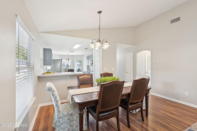 2734 Indigo Hills Ct, Jacksonville, FL 32221 - dining room featuring vaulted ceiling, wood finished floors, arched walkways, a notable chandelier, and visible vents