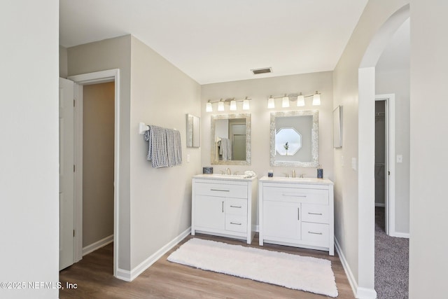 2734 Indigo Hills Ct, Jacksonville, FL 32221 - full bath featuring two vanities, a sink, visible vents, baseboards, and wood finished floors