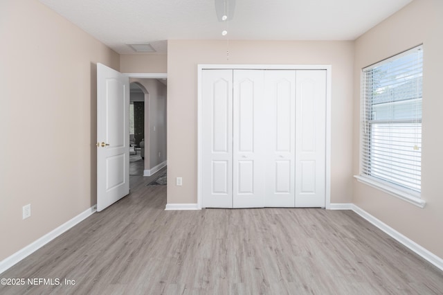 120 Oakwood Plantation Dr, Fleming Island, FL 32003 - unfurnished bedroom featuring a closet, arched walkways, light wood-type flooring, and baseboards