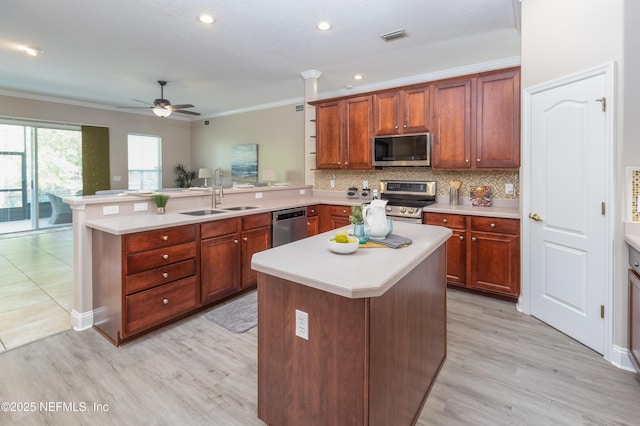 120 Oakwood Plantation Dr, Fleming Island, FL 32003 - kitchen featuring ornamental molding, a peninsula, light countertops, stainless steel appliances, and a sink