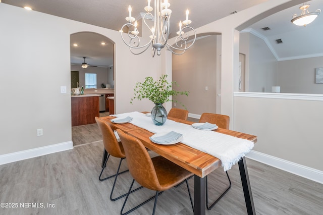 120 Oakwood Plantation Dr, Fleming Island, FL 32003 - dining area featuring baseboards, light wood-type flooring, arched walkways, and vaulted ceiling