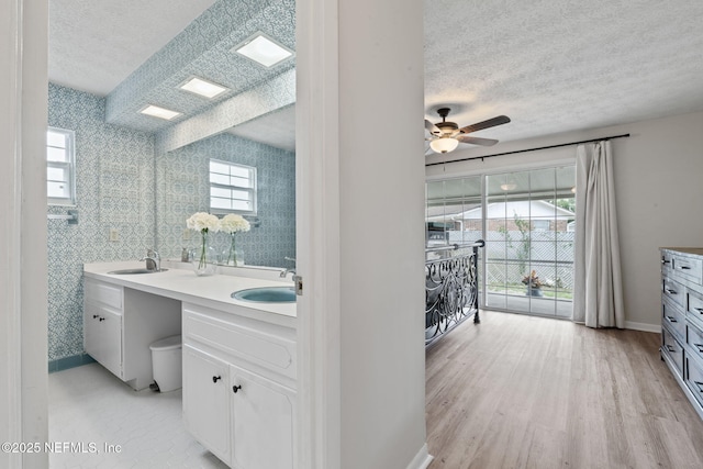 7876 Spanish Oaks Dr, Jacksonville, FL 32221 - full bathroom featuring a textured ceiling, double vanity, a ceiling fan, wood finished floors, and baseboards