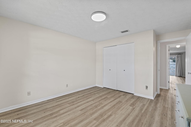 7876 Spanish Oaks Dr, Jacksonville, FL 32221 - unfurnished bedroom with light wood-style flooring, baseboards, a closet, and a textured ceiling
