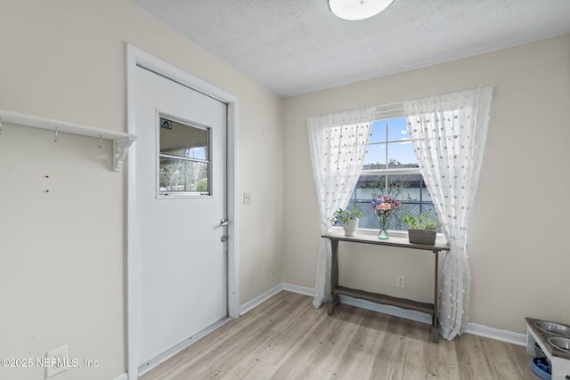 7876 Spanish Oaks Dr, Jacksonville, FL 32221 - doorway to outside featuring wood finished floors, baseboards, and a textured ceiling