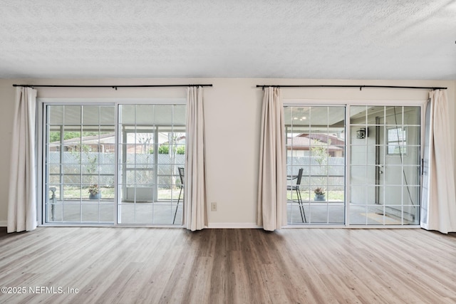 7876 Spanish Oaks Dr, Jacksonville, FL 32221 - unfurnished living room with wood finished floors, a textured ceiling, and baseboards