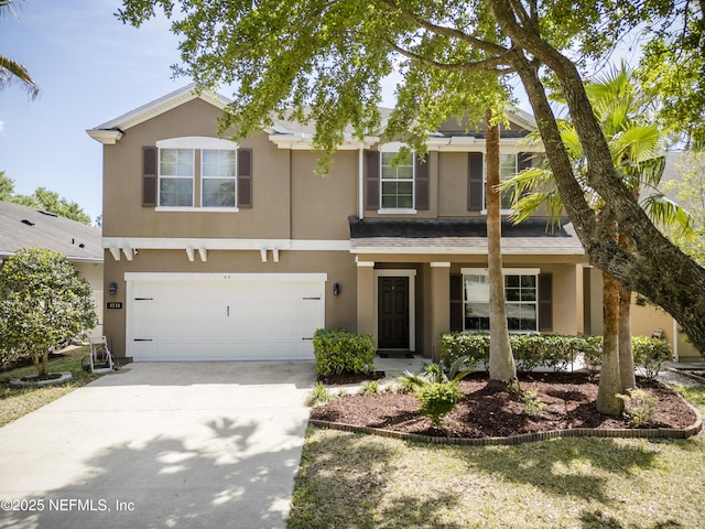 traditional-style house with concrete driveway, a garage, and stucco siding