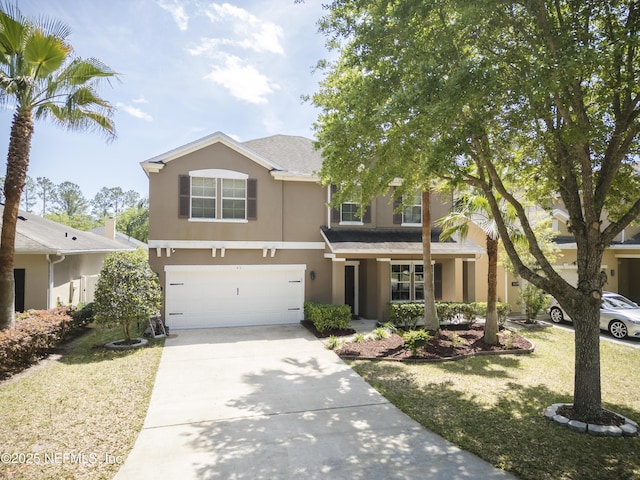 view of front of property featuring concrete driveway, a front yard, stucco siding, and an attached garage