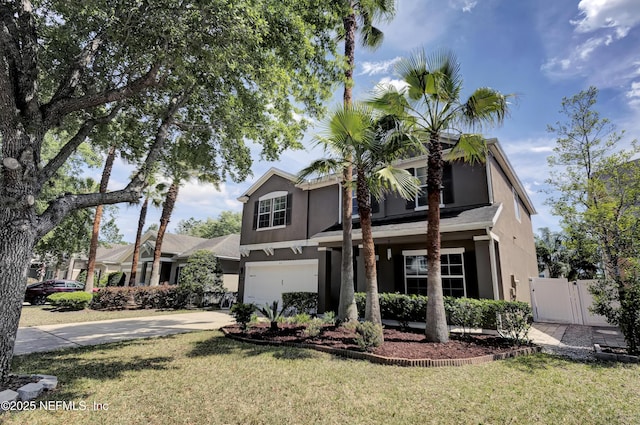 traditional-style house featuring stucco siding, a gate, driveway, a garage, and fence
