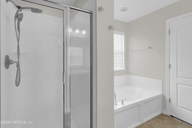full bathroom featuring tile patterned floors, a bath, and a shower stall