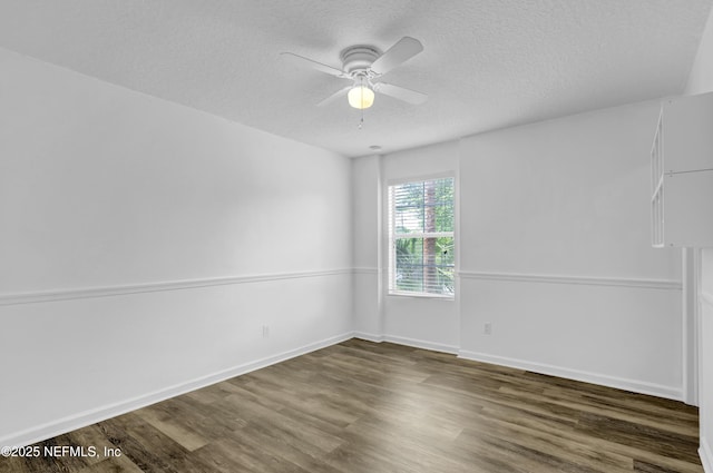 empty room featuring ceiling fan, baseboards, wood finished floors, and a textured ceiling