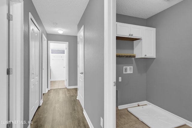 washroom with a textured ceiling, laundry area, baseboards, and hookup for a washing machine