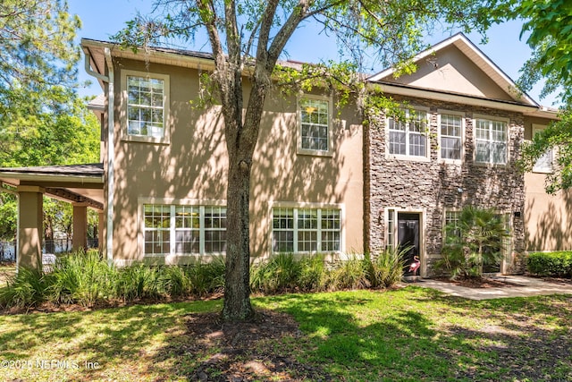7250 Deerfoot Point Cir Unit 1, Jacksonville, FL 32256 - view of front of home with stucco siding, stone siding, and a front yard