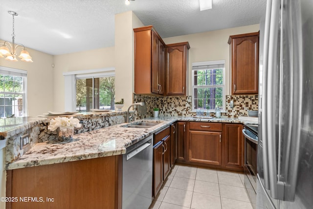 7250 Deerfoot Point Cir Unit 1, Jacksonville, FL 32256 - kitchen with appliances with stainless steel finishes, a sink, light stone counters, and a healthy amount of sunlight