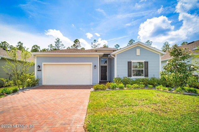single story home with a garage, a front lawn, and decorative driveway