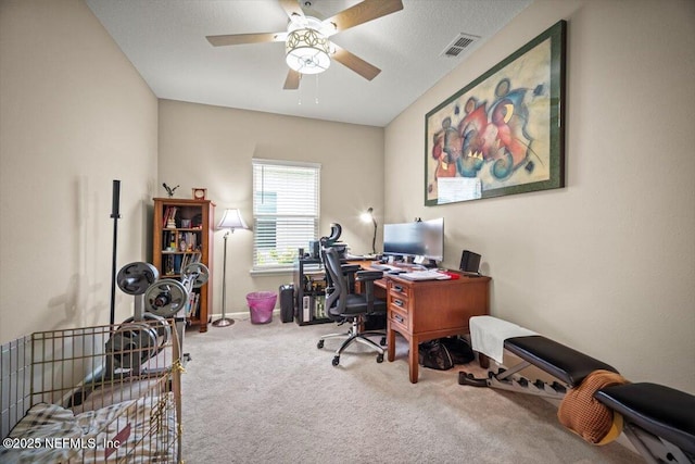 carpeted home office with a ceiling fan and visible vents