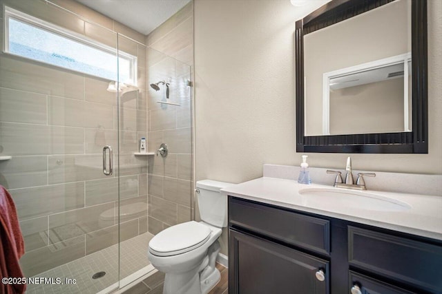 full bath featuring vanity, a stall shower, and toilet