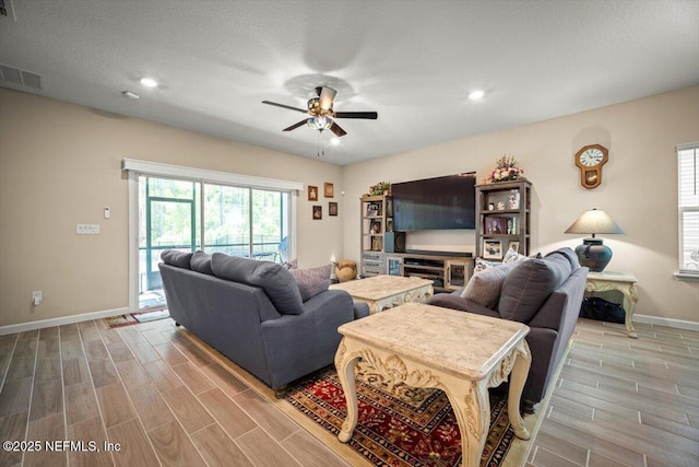 living area featuring a ceiling fan, visible vents, wood finished floors, baseboards, and recessed lighting