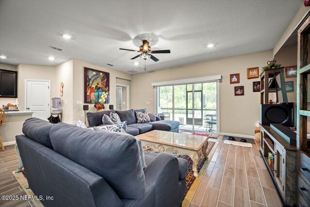 living room with visible vents, baseboards, recessed lighting, a ceiling fan, and light wood-style flooring