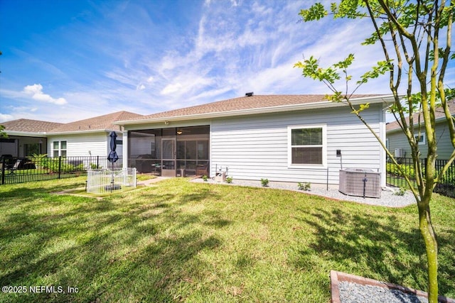 back of house with a lawn, central AC, a fenced backyard, and a sunroom