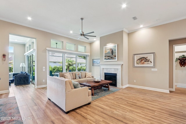 95566 Amelia National Pkwy, Fernandina Beach, FL 32034 - living room featuring a ceiling fan, a tiled fireplace, light wood-style floors, recessed lighting, and healthy amount of natural light