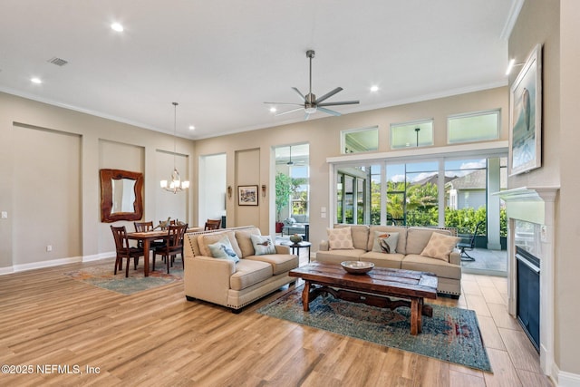 95566 Amelia National Pkwy, Fernandina Beach, FL 32034 - living room with a ceiling fan, recessed lighting, light wood finished floors, ornamental molding, and a glass covered fireplace