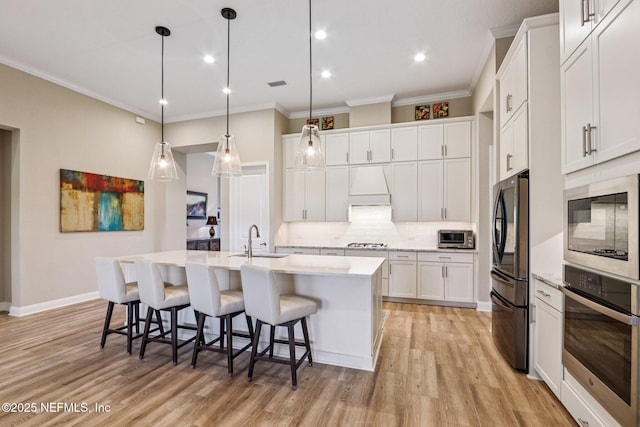 95566 Amelia National Pkwy, Fernandina Beach, FL 32034 - kitchen with black appliances, crown molding, tasteful backsplash, a center island with sink, and white cabinetry