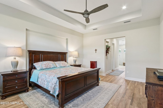 95566 Amelia National Pkwy, Fernandina Beach, FL 32034 - bedroom featuring light wood-type flooring, a raised ceiling, a ceiling fan, and recessed lighting