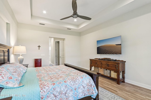 95566 Amelia National Pkwy, Fernandina Beach, FL 32034 - bedroom featuring light wood-style floors, a tray ceiling, recessed lighting, and a ceiling fan