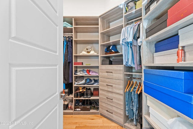 walk in closet with wood finished floors