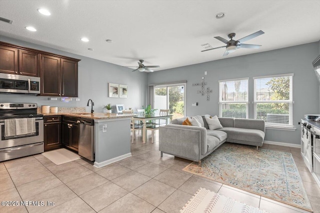 1580 Landau Rd, Jacksonville, FL 32225 - kitchen featuring appliances with stainless steel finishes, a ceiling fan, a peninsula, dark brown cabinets, and recessed lighting